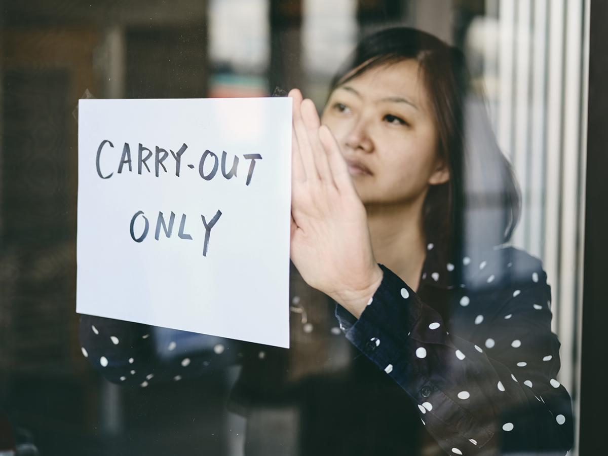 Woman posts "carry-out only" sign in restaurant window