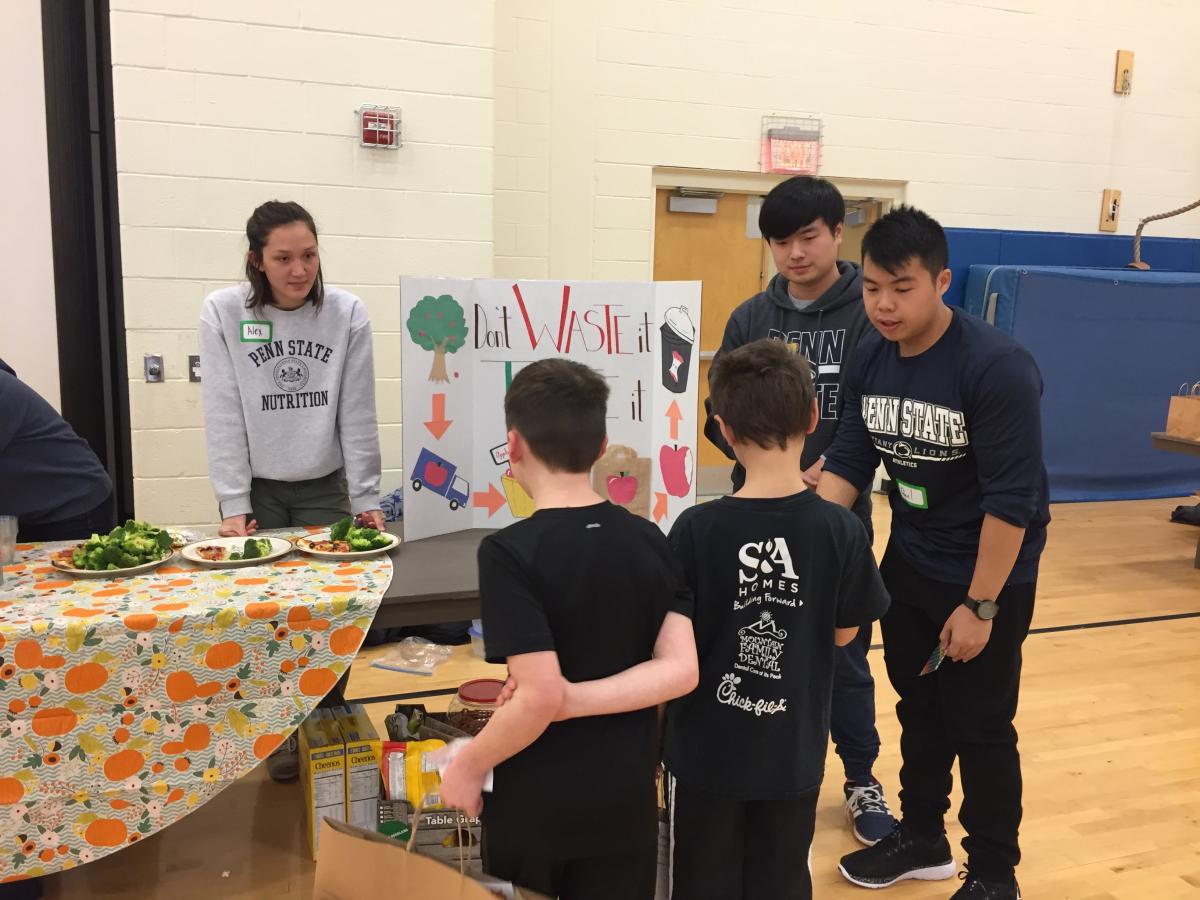 =Students in NUTR 361 interacting with grade school children during a health fair